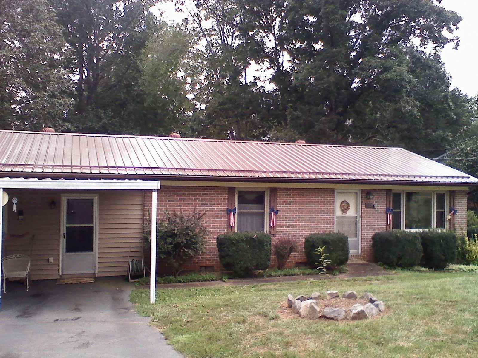 Bronze metal roof and carport on a brick ranch home — Roof Repair work by our crew in Mendon